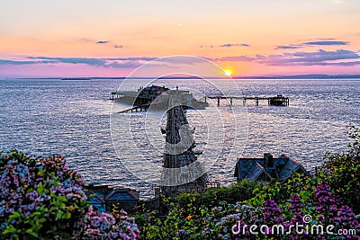 Sunset Weston-super-Mare Birnbeck old pier Somerset UK with pink flowers Stock Photo