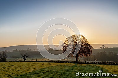 Colourful sunrise on a summer morning with a little fog on the ground and spectacular views over the Dutch hillside in Limburg Stock Photo