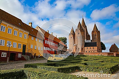 Colourful traditional houses along the road with the Church of Our Lady in the background, Kalundborg, Denmark. Stock Photo