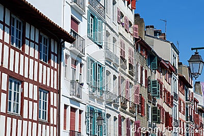 Colourful vintage facades of typical french basque homes with shutters and windows of faded colours downtown in Bayonne, Basque Stock Photo