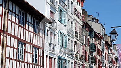 Colourful vintage facades of typical french basque homes with shutters and windows of faded colours downtown in Bayonne, Basque Editorial Stock Photo