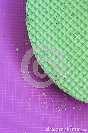 Colourfull green waffles on purple desk. Textured abstract background. Close up. Flat lay Stock Photo