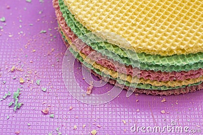 Colourfull waffles on purple desk. Textured abstract background. Close up. Stock Photo