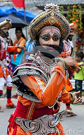 A colourfully dressed dancer performs through the streets during the Hikkaduwa Perahera Editorial Stock Photo