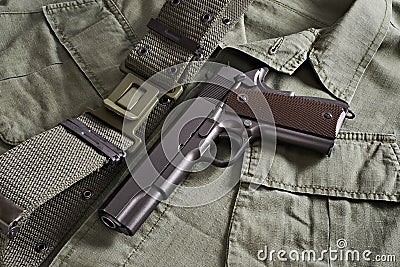 Colt pistol and belt lie on military jacket Stock Photo