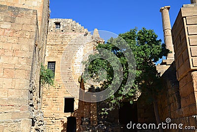 Columns on the hellenistic stoa of the Acropolis of Lindos, Rhodes, Greece, Blue sky, olive tree and beatiful sea view in the back Stock Photo