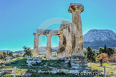 Columns in ruins of Temple of Apollo with Acrocorinth the acropolis of ancient Corinth - a monolithic rock overseeing the ancient Editorial Stock Photo