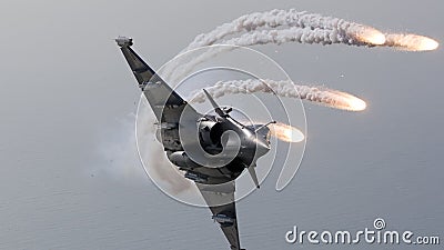 Combat fighter demonstrates anti-missile maneuver with the deployment of false heat targets during air show Stock Photo