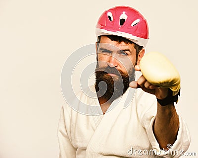 Combat master gets ready to fight. Martial arts concept. Man with beard in kimono and pink helmet on white Stock Photo