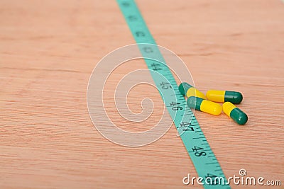 the combination of slimming pills and measuring tape, providing individuals with effective tools to support their dietary choices Stock Photo