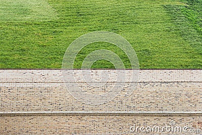 Combination of two textures - trimmed grass and brown brick wall Stock Photo