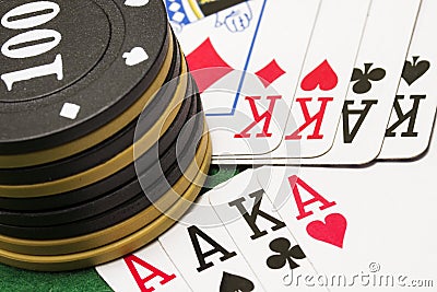 Combinations of playing cards lie under a column of chips for poker Stock Photo