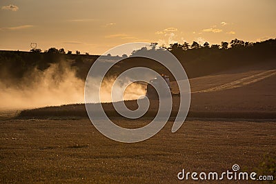 Combine harvested grain at sunset Stock Photo