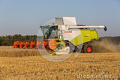 Republic of Tatarstan - August 5, 2020: Combine harvester of wheat in a summer landscape of endless fields Editorial Stock Photo