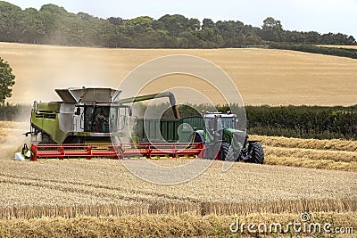 Combine harvester working in a field of wheat - England Editorial Stock Photo
