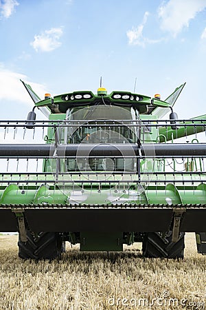 The combine harvests ripe wheat in the grain field. Agricultural work in summer. Detail of the combine close-up. Editorial Stock Photo