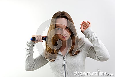 combing hair with a blue comb on a white background beautiful well-groomed healthy hair of a teenage girl adolescence Stock Photo