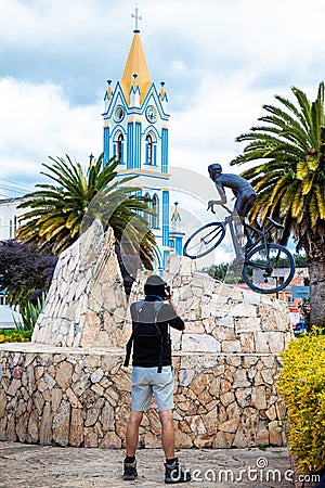 COMBITA, COLOMBIA - AUGUST 2023. Tourist taking pictures of the life-size monument in honor of the famous cyclist Nairo Quintana Editorial Stock Photo