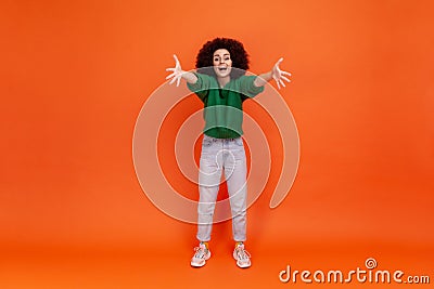 Come to my arms. Full length of friendly young adult woman with Afro hairstyle wearing green casual Stock Photo