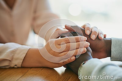 Comfort, kindness and forgiveness with a biracial couple holding hands, united in support in a crisis. Caring wife Stock Photo