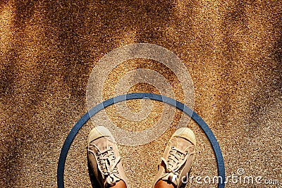 Comfort Zone Concept. Male on Sneaker Shoes Standing inside a Circle Line, Top View, Grunge Dirty Concrete Floor with Sunlight as Stock Photo