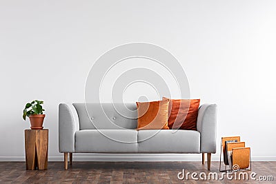 Comfortable couch with orange and red pillow in spacious living room interior, Stock Photo