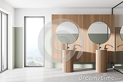 Comfortable two sinks with round mirrors standing on concrete floor in modern bathroom with wooden wall and panoramic windows Stock Photo