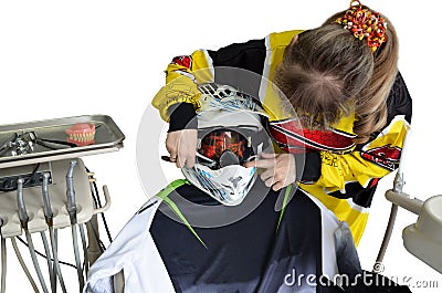 Comic, girl dentist treats a patient in a helmet Stock Photo