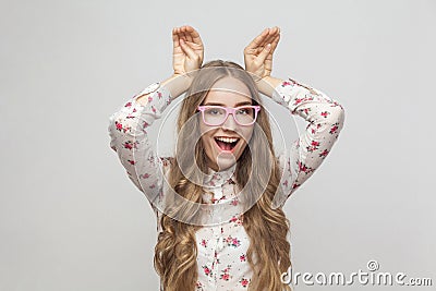 Comic woman in pink glasses holding hands look`s like rabbit ear Stock Photo