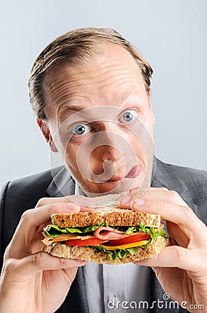 Comical man eating sandwich with funny expression Stock Photo