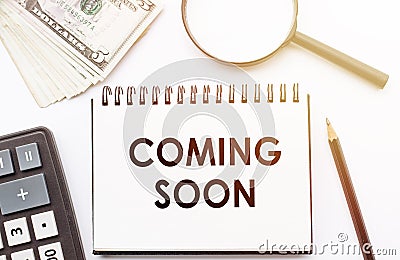 Coming Soon word with Notepad, glasses, calculator, nagnifier and pencil on yellow background Stock Photo