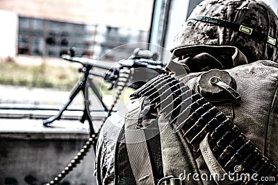 Commando soldier machine gunner firing from window Stock Photo