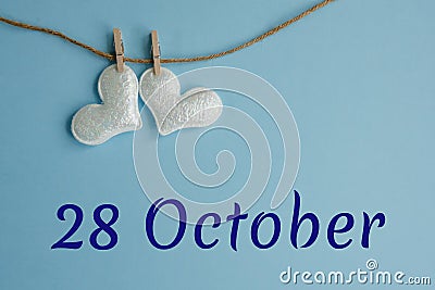 Commemorative date October 28 on a blue background with white hearts with clothespins, flat lay. Holiday calendar Stock Photo