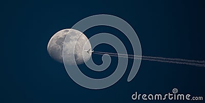 High-Altitude Airliner Passes in Front of Moon Stock Photo