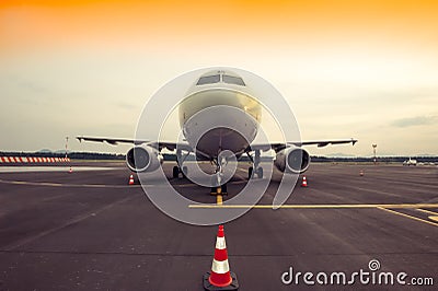 Commercial airplane parking at the airport, with traffic cone in Stock Photo