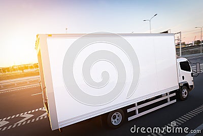 Commercial cargo delivery truck with blank white trailer driving on highway. Stock Photo