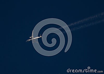Commercial Jet with Contrails at Sunset Stock Photo
