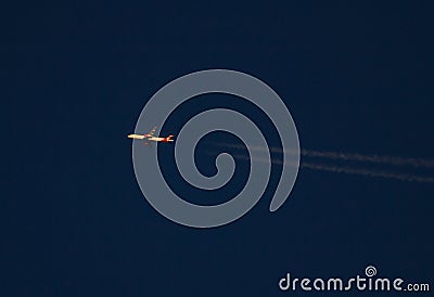 Commercial Jet with Contrails at Sunset Stock Photo