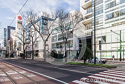 Commercial modern building with leafless trees on traffic island in Sapporo in Hokkaido, Japan Editorial Stock Photo