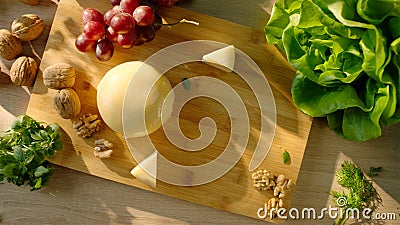 Commercial pack shot with cheese, grapes, walnut and greens on serving board Stock Photo