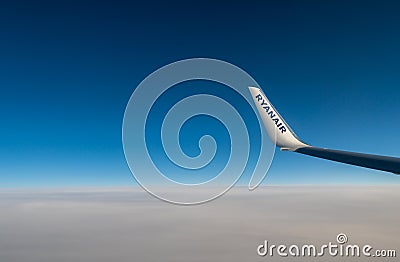 06/09/2021. Commercial Ryanair airborne airplane at high altitude. Cabin window view at wing with company name. Editorial Stock Photo