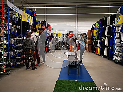 Commercial worker arranging the products and customers at Decathlon Editorial Stock Photo