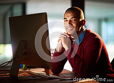 Committed to the deadline. Portrait of a handsome young man working late in his office. Stock Photo