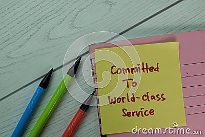 Committed To World-Class Service write on sticky notes isolated on Wooden Table Stock Photo