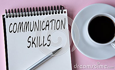 COMMUNICATION SKILLS - words written in a notebook on the background of a cup of coffee and a pen Stock Photo