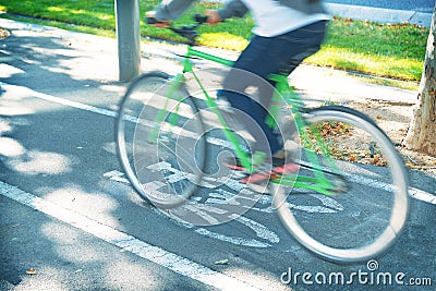 Commuter person riding a bicycle on a urban bike lane in Barcelona. Active lifestyle and ecology awareness concept Stock Photo