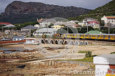 A commuter train at Kalk Bay harbour beach Editorial Stock Photo