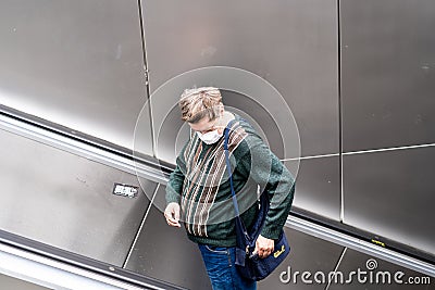 Commuters on a subway escalator with face masks due to Coronavirus Editorial Stock Photo