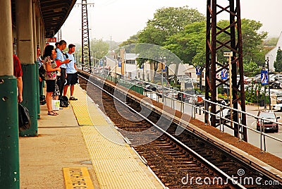 Commuters wait for their train on a platform Editorial Stock Photo