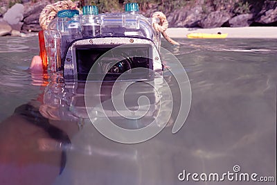 Compact camera and housing floating on the sea. Stock Photo